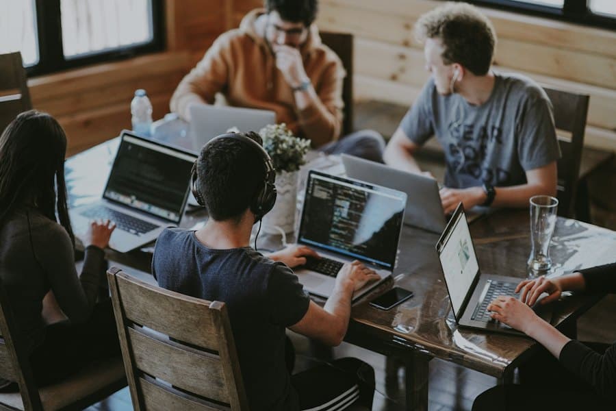 A team building on laptops around a shared table